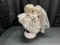 Front view of the Enesco Precious Moments wedding musical figurine showing the bride and groom embracing on a floral base.