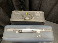 Photo of top of two vintage suitcases, Skyway and American Tourister Tiara, both blue with metal latches and handles