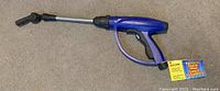 Full view of Aldon car wash sprayer showing blue plastic body, metal spray tube, and adjustable nozzle tip.