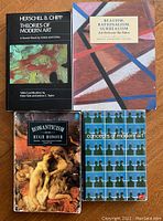 Four art theory books on wooden surface: 'Theories of Modern Art', 'Realism, Rationalism, Surrealism', 'Romanticism', and 'Concepts of Modern Art'.