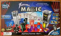 Top front of the Fantasma Magic Astounding Set box showing the contents including metal rings, magic cards, dice, cups, and a magic box device. Highlight of 150+ tricks and instructional video included.