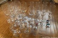 Top view showing mixed collection of crystal stemmed glasses of various shapes and sizes with colorful markers attached at base.