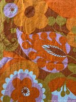 Close-up showing fine linen fabric and colorful Mid-Century Modern floral and paisley pattern in orange, purple, brown, and green shades.