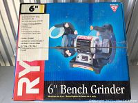 Front of the Ryobi bench grinder box showing brand, model, and product image.