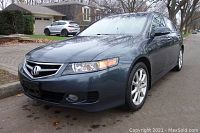 Front right quarter view showing headlights, grille, alloy wheel and metallic grey paint