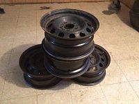 Photo of all four black steel wheels stacked, showing size and condition