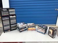 Photo shows multiple stacks of DVDs and CDs with some DVD box sets including the Foyle's War series prominently displayed.