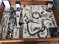 Wide top view of the collection showing numerous costume jewelry pieces laid out, including necklaces, earrings, bracelets, and watches.