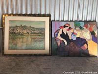 Two framed art prints placed side by side on floor showing landscape on left and figurative scene on right with frames aged and scratched