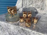Front left view of amber gold glasses grouped on and around a covered glass dish showing patterns and color.