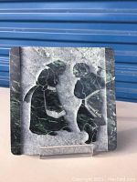 Front view of the square greenish marble relief sculpture depicting two Hassidic dancers.