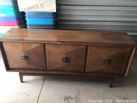 Full view of mid century dresser showing three drawers, tapered legs and overall finish