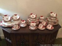 Overall view of incomplete Paragon Rockingham set displayed on wood sideboard