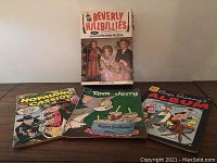 All four items displayed: Hopalong Cassidy, Tom and Jerry, Bugs Bunny comics, plus Beverly Hillbillies puzzle box with wear.