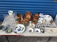 Full lot on table showing porcelain, crystal, wooden bowls, and decorative items including glass marbles and figurine.