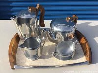Aluminum coffee pot, teapot, creamer and sugar bowl arranged on serving tray
