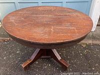 Top view of the round wooden dining table showing surface grain and wear.