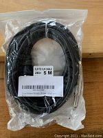 Packaged black XLR to XLR microphone audio cable coiled with visible barcode label showing length and cable type.
