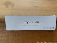 Photo of the white rectangular box of the stylus pen, showing product name, features, and compliances.
