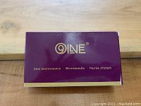 Box labeled QINE Skin Maintenance Microneedle Nurse System, purple with gold text and trim.