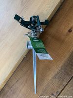 Full view of the Orbit zinc impact sprinkler attached to a metal spike, showing the sprinkler head and ground spike.