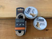 Photo showing Meilemeng Urban Fashion dog leash packaged with black, beige, and metal clasp and two Mooray branded round tins of flea & tick collars for dogs
