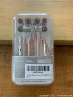 Front of the earphone packaging showing the white and silver in-ear earphones and additional earbud tips included above.