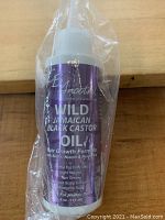 Full view of Wild Jamaican Black Castor Oil bottle with pump dispenser sealed in plastic wrap.