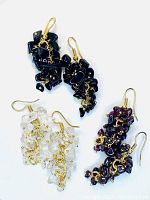 Three pairs of gemstone cluster earrings: black onyx, crystal quartz, cherry red garnet on brass wire hooks laid flat.