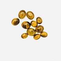 Eleven oval polished Tiger's Eye cabochon gemstones arranged on a white background, showing their natural bands and chatoyant sheen typical of Tiger's Eye.