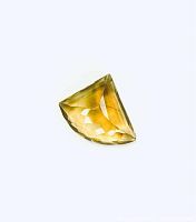 Front view of the lemon quartz gemstone showing its transparent yellow color and intricate multi-faceted cut in a semi-triangular shape.
