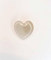 Front view of the translucent hand-carved white agate heart gemstone on a white background.