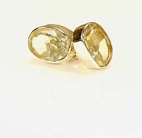 Pair of light green faceted prasiolite stones set in sterling silver bezels, photographed from a front angle showing the stone and setting details.