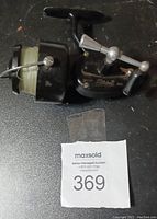 Photo of one Mitchell spinning fishing reel with fishing line attached on spool, showing condition and model details.