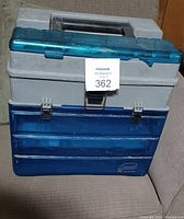 Closed view of blue and gray Plano fishing tackle box showing secure latches and handle.