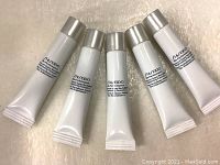 Five white tubes of Shiseido Bio Performance Advance Super Revitalizer Brightening Formula with silver caps laid out on a textured surface.
