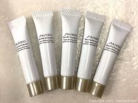 Front view of five white tubes of Shiseido Bio Performance Super Refining Essence 20ml with gold caps, aligned side by side.
