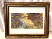 Full view of the framed Claude Monet Water Lilies print showing the wooden frame and artwork.