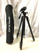 OPTEX Black TP160 tripod fully extended standing upright next to its carrying bag with strap.