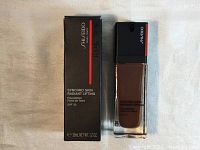 Photo of Shiseido foundation bottle next to its box showing label and packaging.