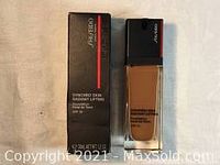 Photo showing Shiseido foundation bottle and box with product name Synchro Skin Radiant Lifting.