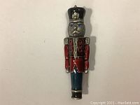 Front view of the Nutcracker soldier brooch pin showing detailed facial features, colored enamel paint on jacket, pants, and hat.