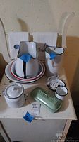 Wash basin stand showing towel rail, single door, and enamelware including large and small pitchers, bowls, plates, and night pot.