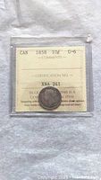 Front of coin in a protective sleeve showing date 1858, denomination 10 cents, and ICCS grade G-6 with certification number