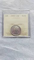 Photo showing front side of 1881 Canada 25 cent silver coin in plastic sleeve with ICCS grading card visible.