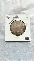 Front side of 1900 Canadian 50 cent coin in white cardboard holder with label