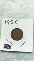 Obverse side of the 1925 Canadian one cent coin in white cardboard holder.