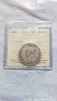 Front of the 1914 Canadian 50 cents coin showing King George V and certification details visible through the protective case.