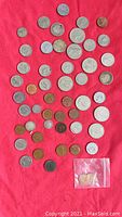 Overview of Canadian coin assortment on red background including silver dimes, quarters, pennies, and nickels.