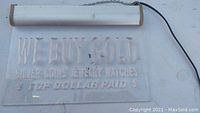 Clear acrylic lighted hanging sign with etched text detailing services related to gold, silver, coins, jewelry, and watches. White light fixture attached on top with end caps and attached power cord. Chain used for hanging.